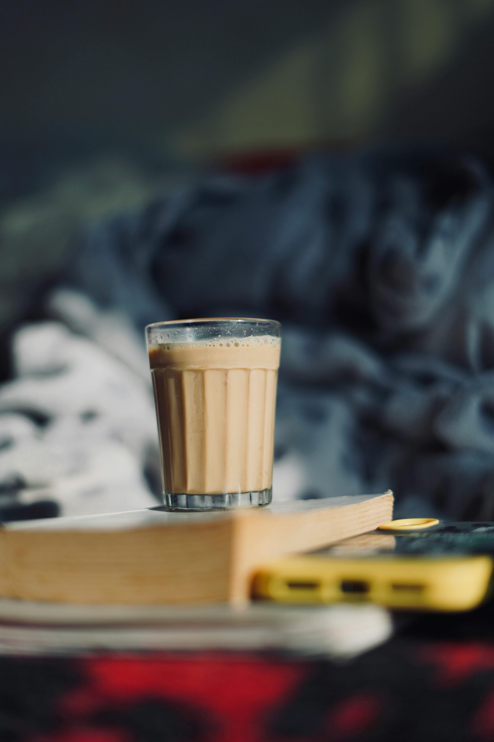 A warm, relaxing setup with a glass of iced coffee on a book indoors.