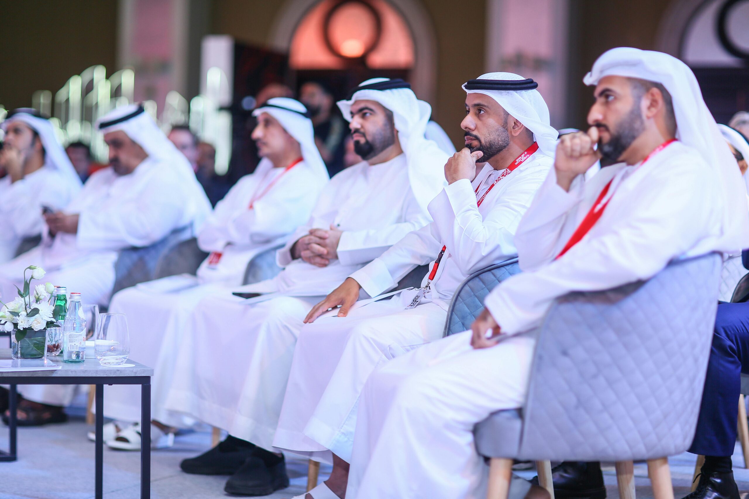 A business meeting in Dubai with men wearing traditional Middle Eastern clothing, focused and engaged.